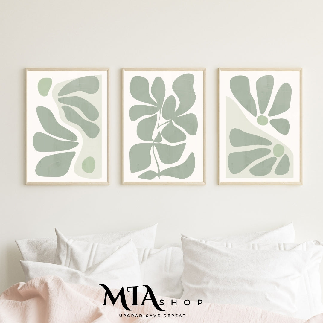 Three framed abstract green leaf prints on a wall above a bed with 'MIA Shop' branding.